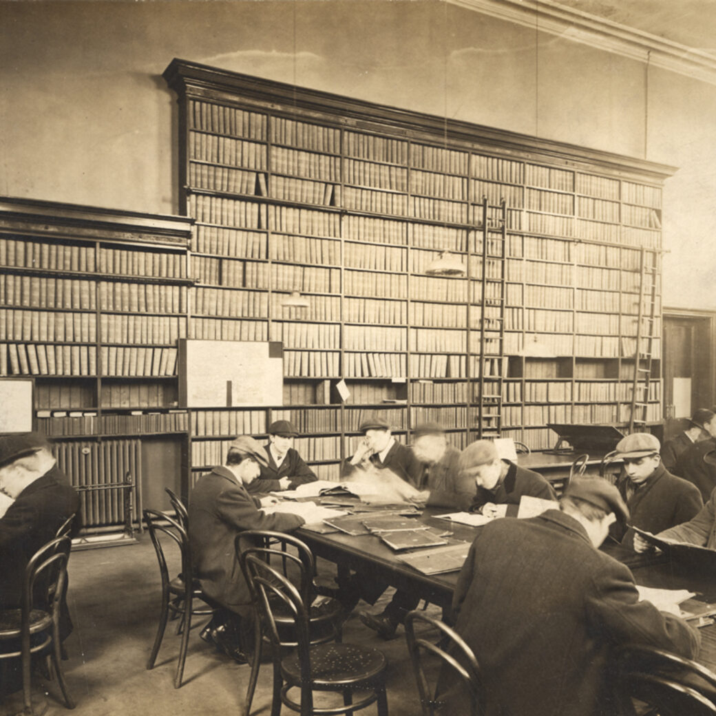 An archival reading room with students at long study tables