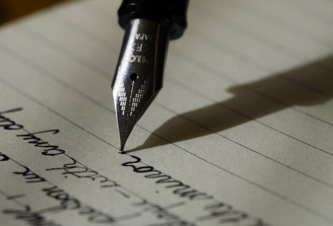 A fountain pen resting on a handwritten page