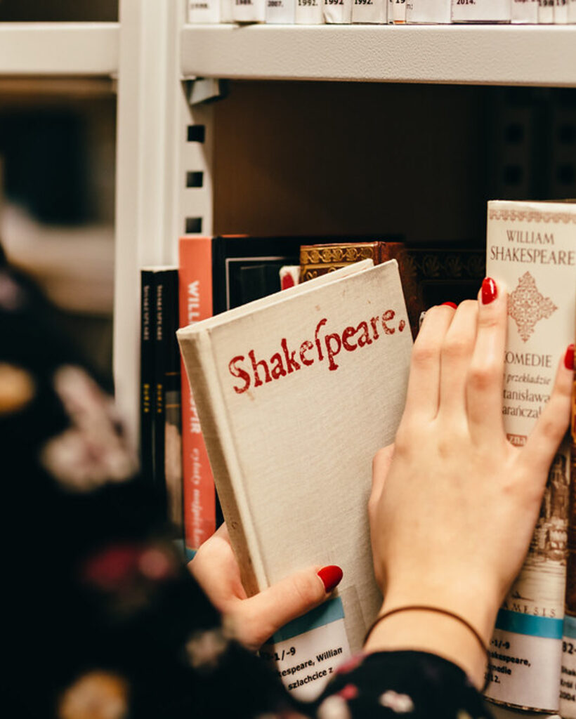 A young reader holding an open book in a quiet library